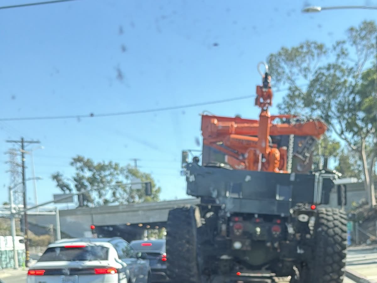 Crane truck loaded on a low-bed trailer in Los Angeles traffic