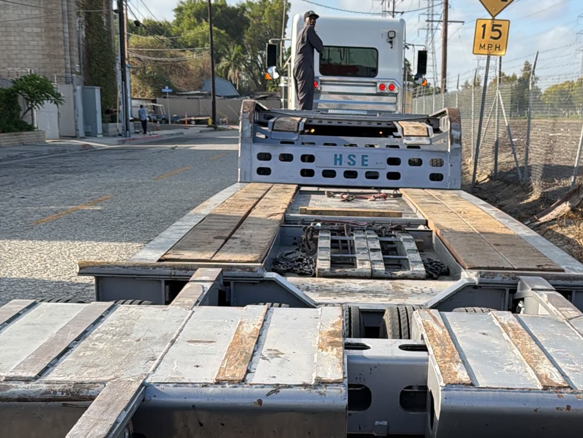 Low-bed trailer deck with the ramps down, ready to load